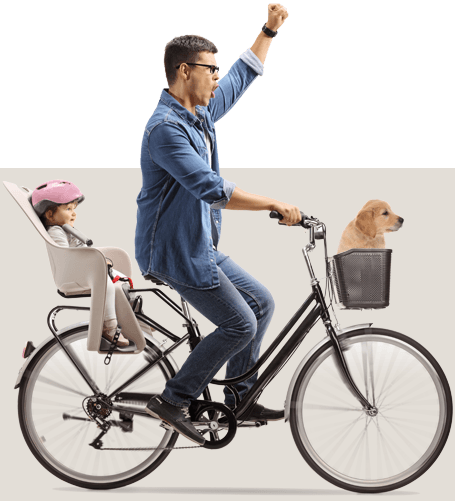 Dad riding a bike with a child in a carrier on the rear and a puppy in the front basket